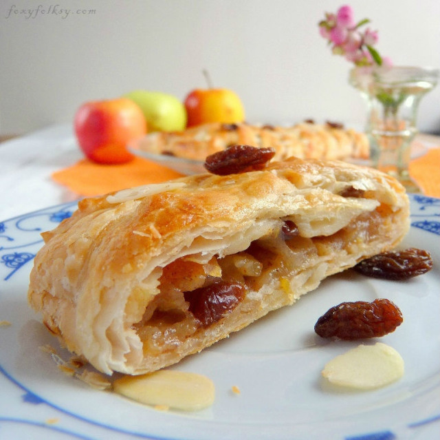 Try this easy recipe for apple strudel that is done in a few minutes. Tart apples, raisins, nuts and cinnamon baked in a light, flaky, crispy puff pastry. | www.foxyfolksy.com