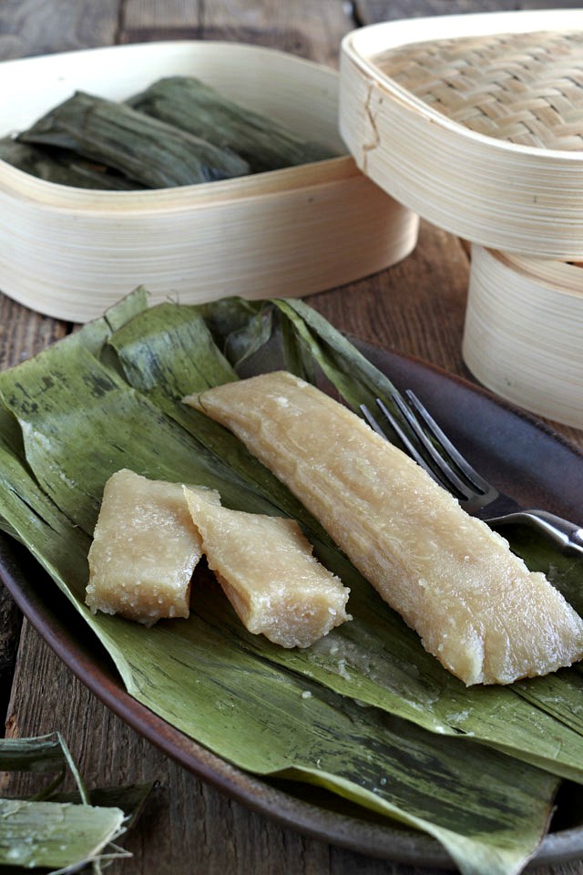 Cassava Suman is a Filipino delicacy of steaming a mixture of grated cassava, coconut milk, and sugar in banana leaves. Try this great Cassava recipe now! | www.foxyfolksy.com