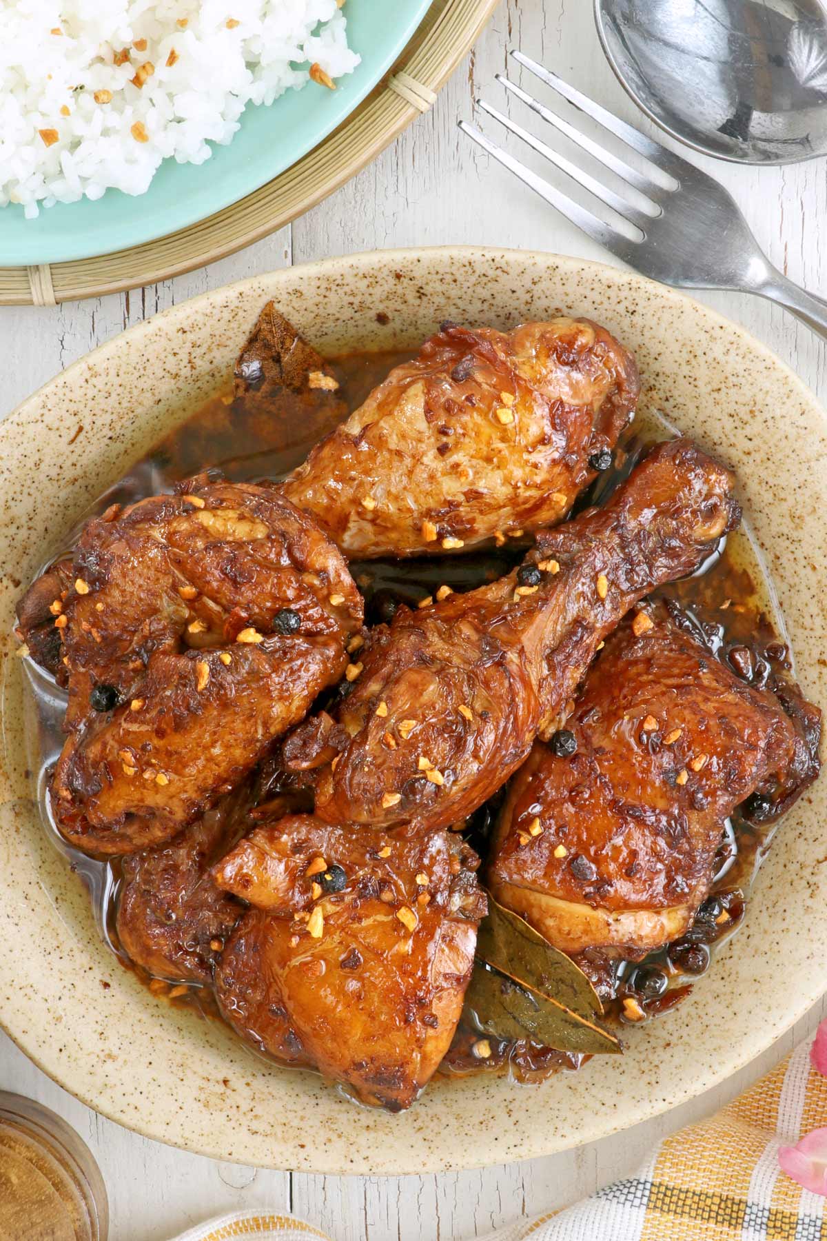 A plate with Adobong Manok werved with rice.