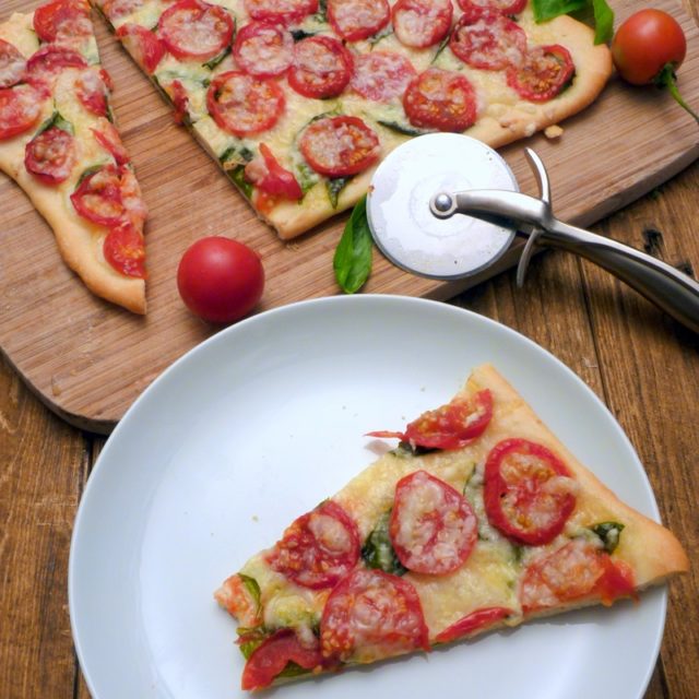 I never thought such a simple and meatless pizza could taste this good! With four basic ingredients, tomato, basil, olive oil and cheese on top of a homemade thin crust pizza dough! | www.foxyfolksy.com
