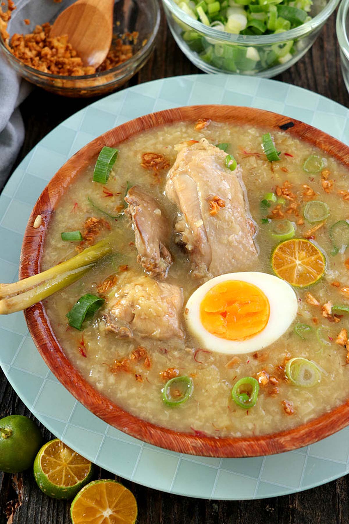 Filipino Arroz Caldo from glutinous rice, chicken, ginger, lemongrass with hard-boiled egg and brown garlic toppings