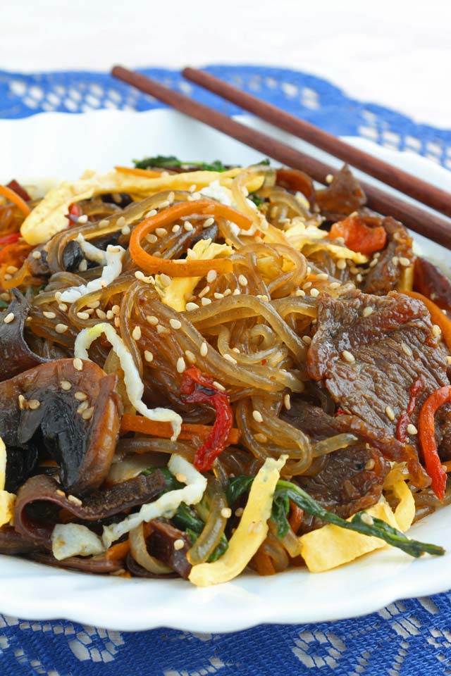 Japchae served on a plate with chopstick