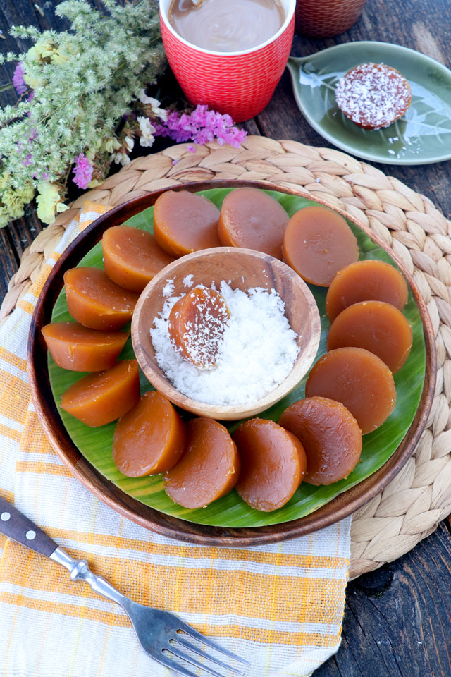 Brown sticky rice cake served on plate with grated coconut