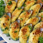 Easy Baked Mussels stuffed with garlic bechamel sauce and topped with cheese.