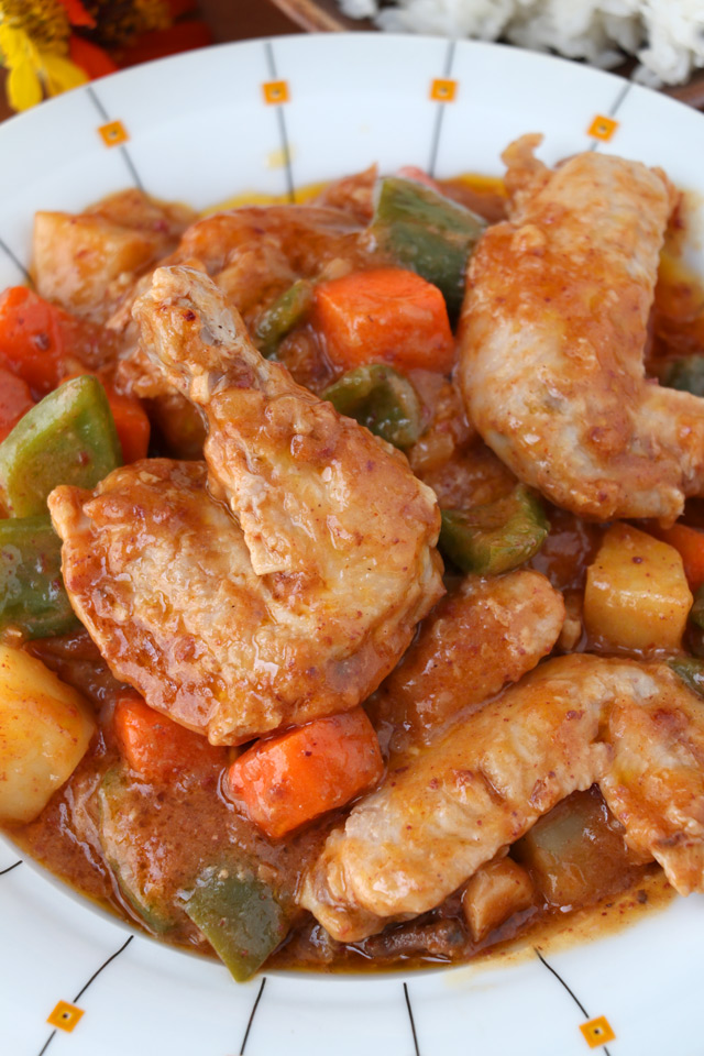 Chicken stewed in tomato sauce with carrots, potatoes, and bell pepper.