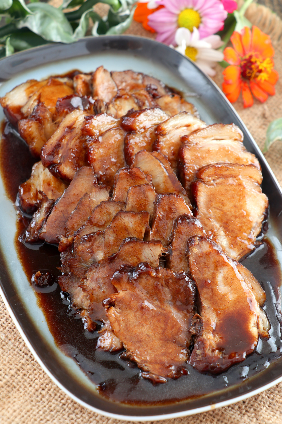 Slices of pork with sweet sticky dark sauce.