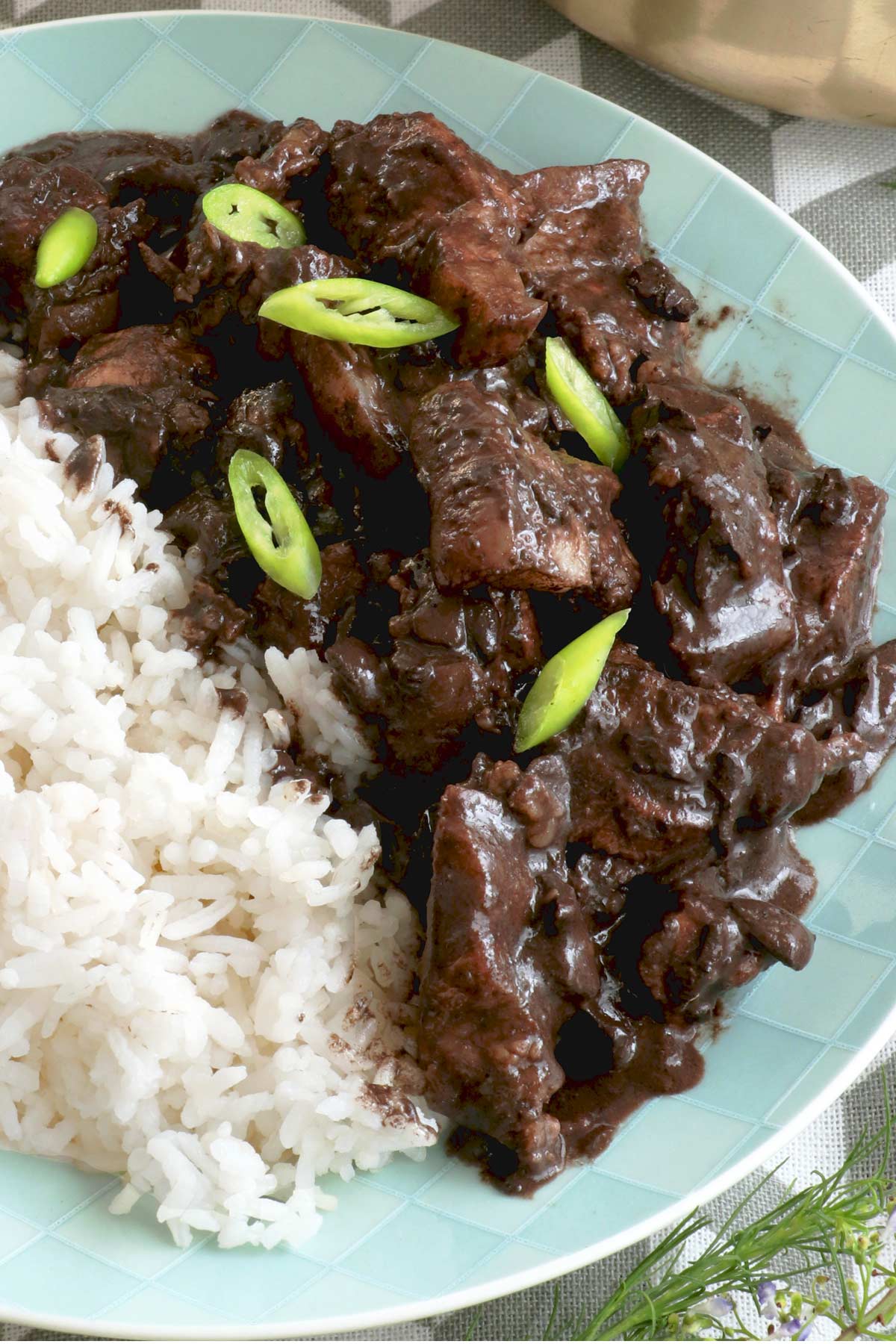 Dinuguan with rice on a plate.