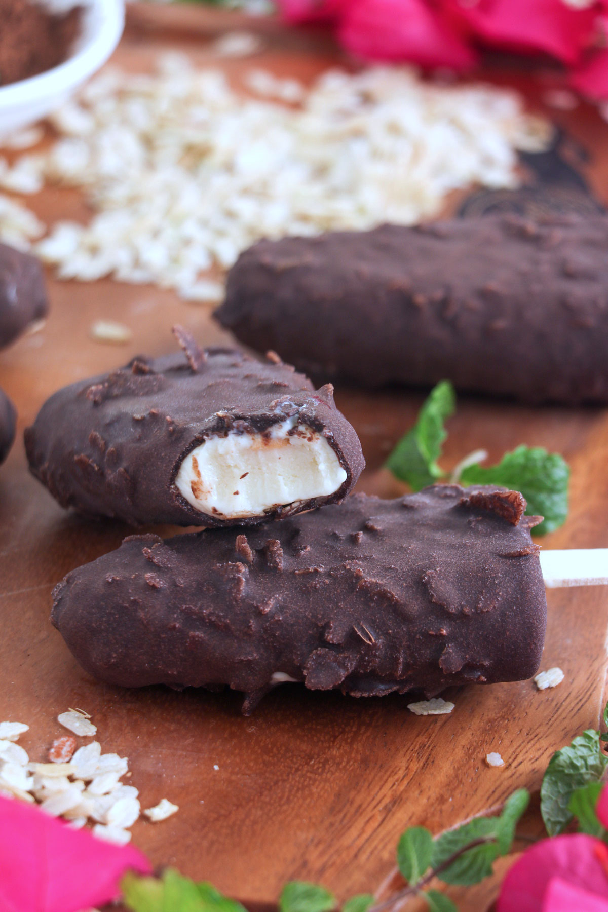 Chocolate-coated vanilla ice cream on stick with pinipig.