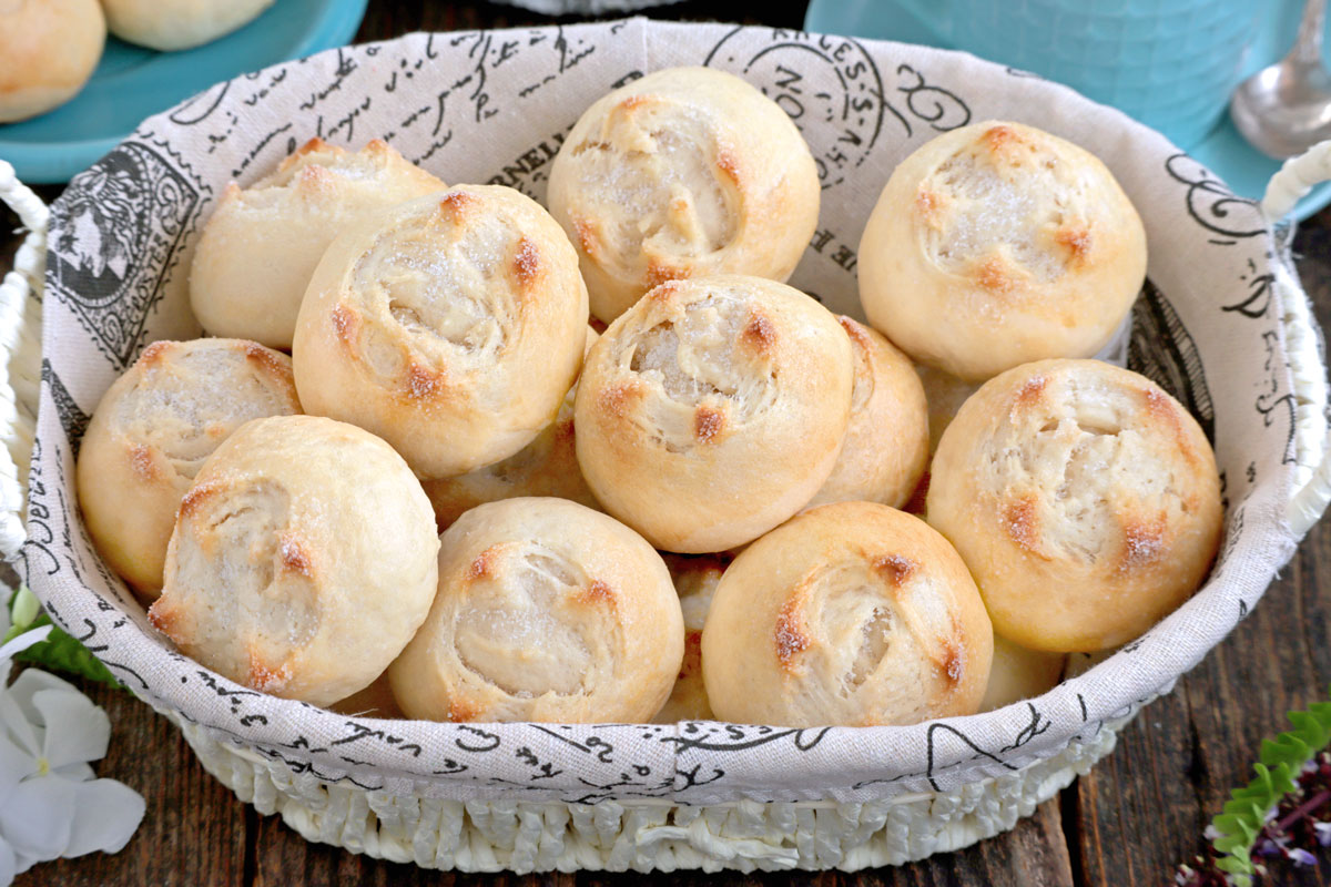 Putok or Star Bread, small dense buns with cross-shaped fissure on top dusted with sugar.