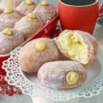 Vanilla pastry cream-filled doughnuts on a plate.
