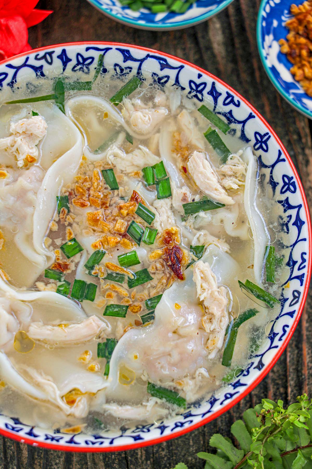 Pancit Molo, a soup dumpling with shredded chicken, toasted garlic and green onions, served on a bowl.