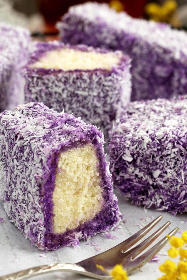 Cake bars dipped in ube glaze and coated with coconut flakes.