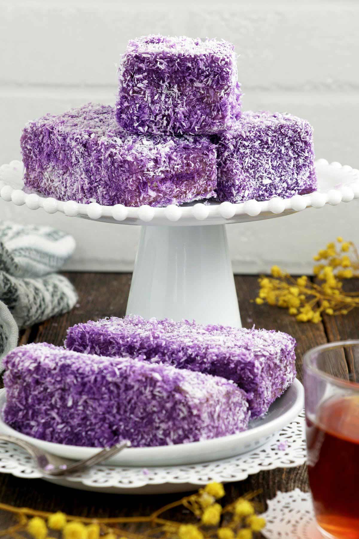 Homemade Ube bars are cake bars coated with purple yam glaze and coconut flakes.