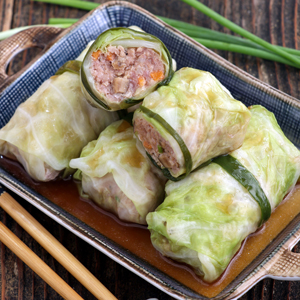 Asian stuffed cabbage rolls on a serving plate.