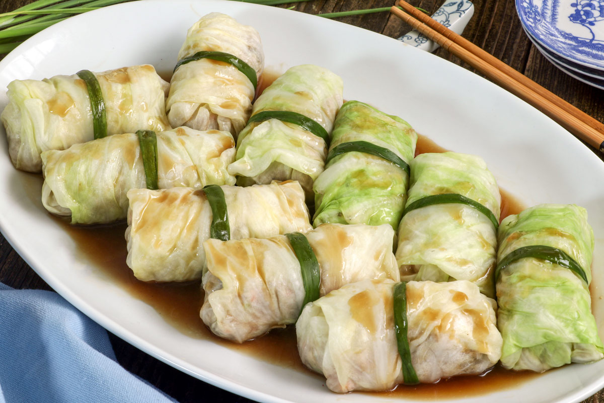 Asian stuffed cabbage rolls on a serving plate.