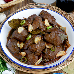 Adobong Atay ng Manok in a serving platter garnished with fried garlic slivers.