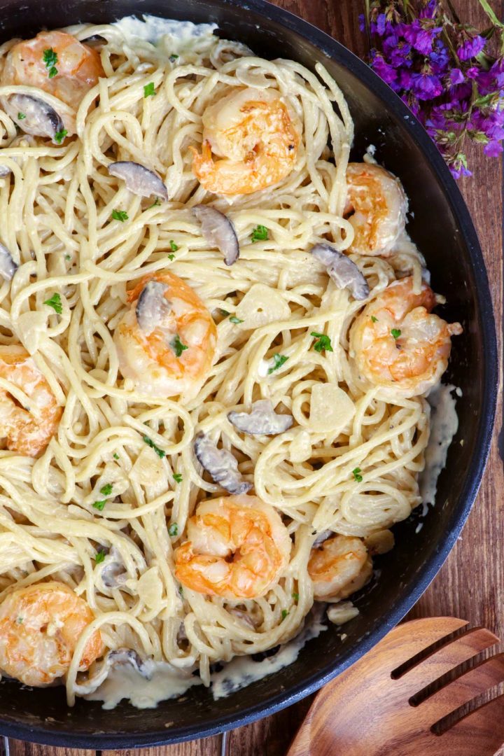 Freshly cooked creamy prawn pasta with thick garlicky white sauce and studded with mushrooms.