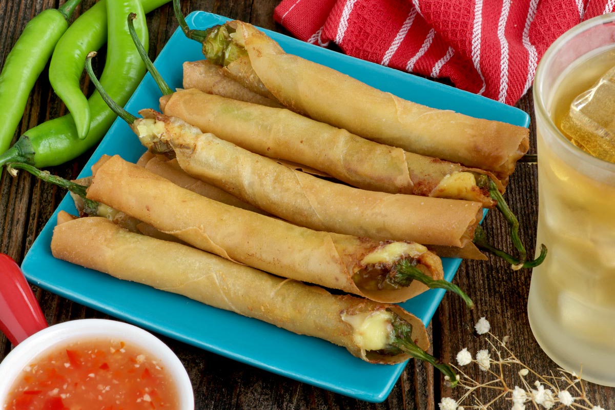 Dynamite Lumpia roll served with sweet and sour sauce and beer on the side.