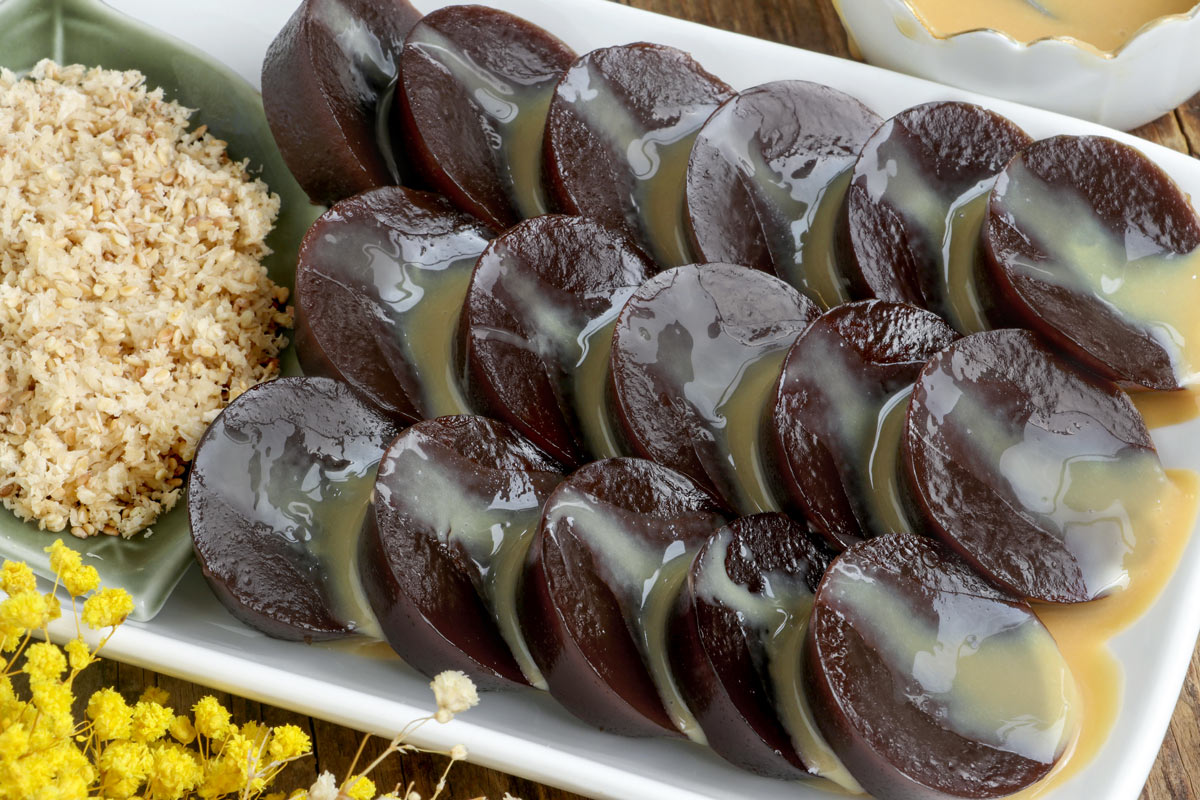 Black Kutsinta on a serving plate glazed with dulce de leche with desiccated coconut on the side.