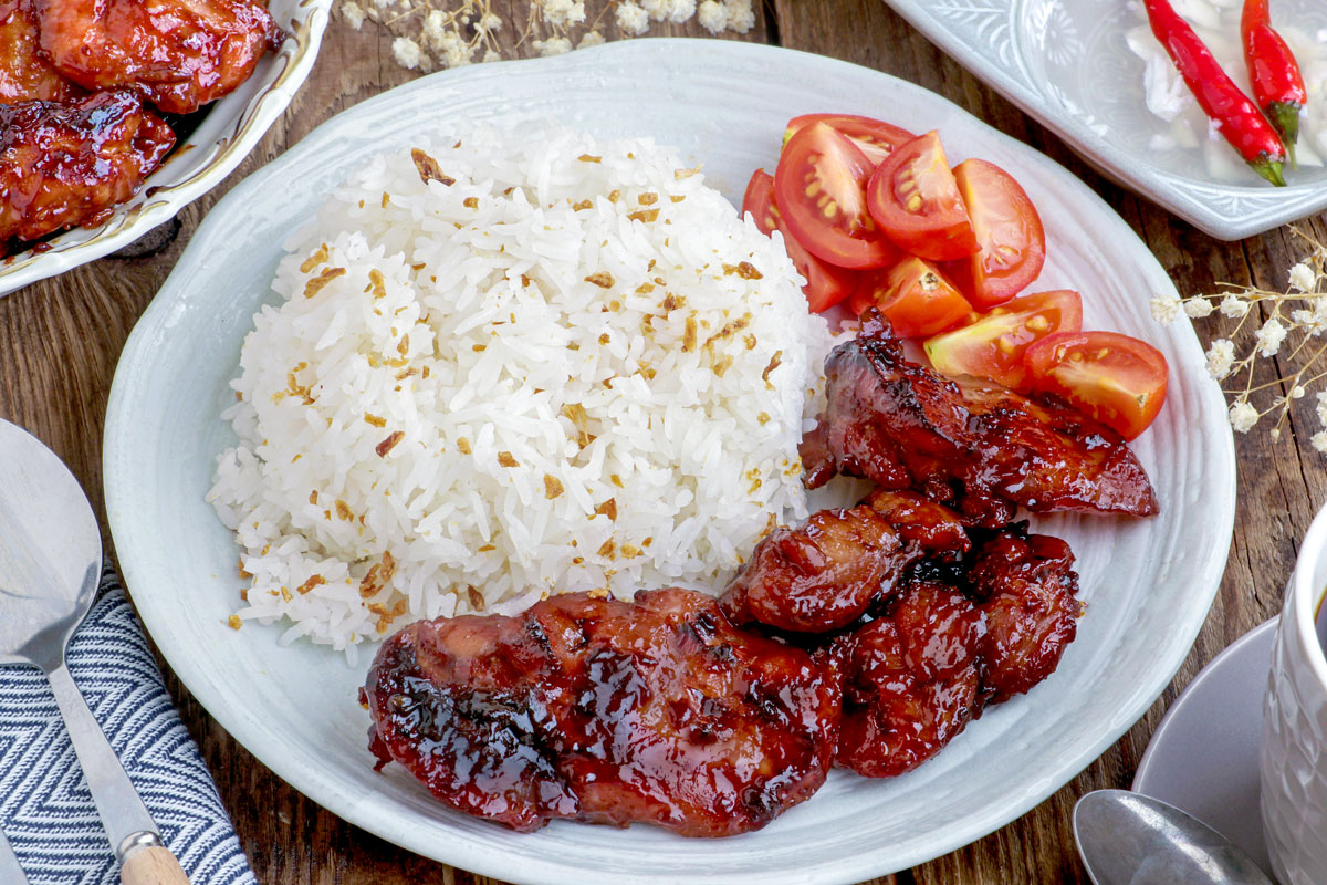 Chicken Tocino in a plate with garlic fried rice and sliced tomato.