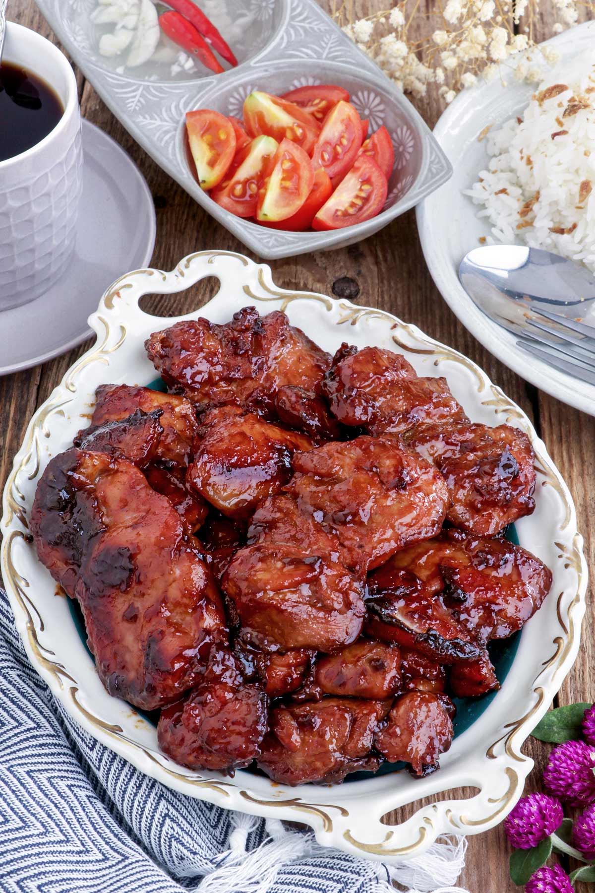 Chicken Tocino on a serving plate served with, coffee, garlic rice and slices of tomato.sl
