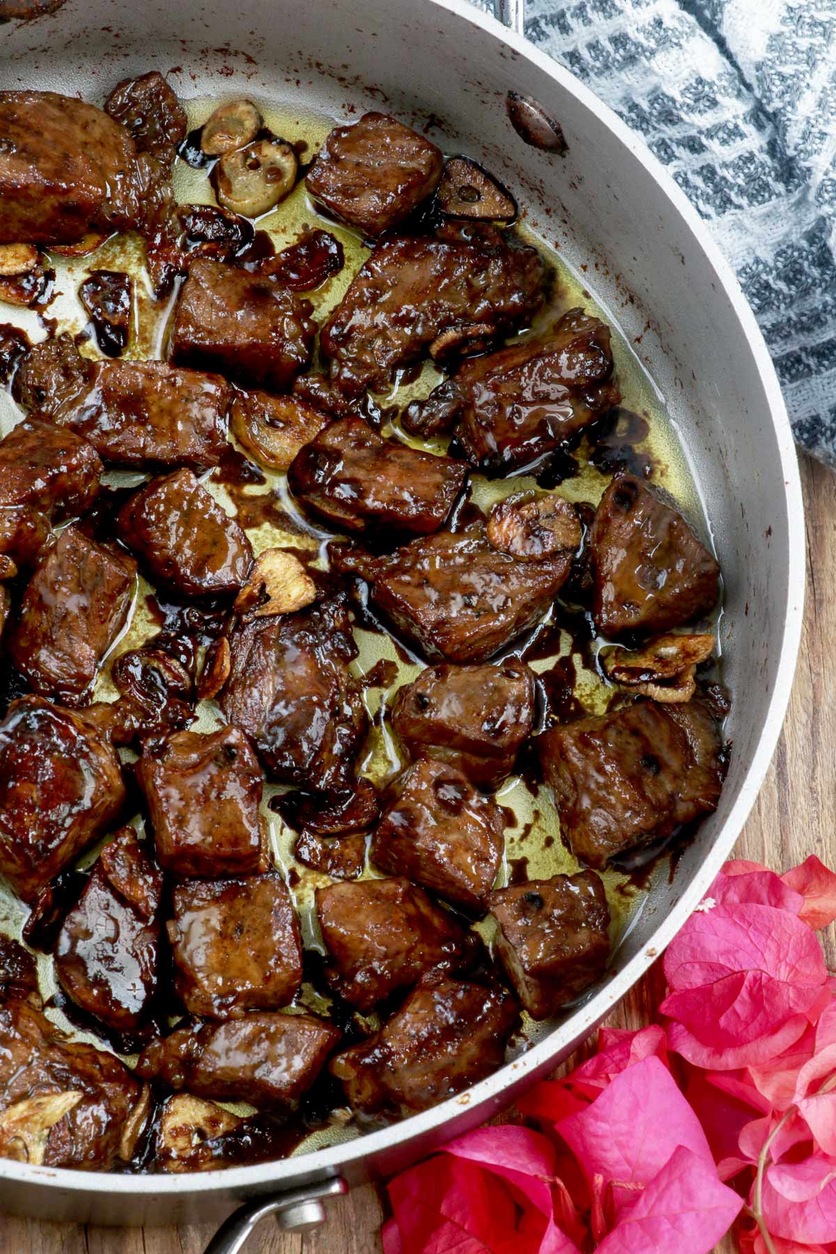 Freshly cooked Beef Salpicao in a pan with fried garlic bits in a savory sauce.