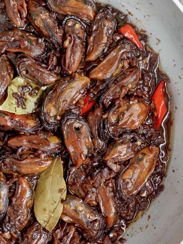 Freshly cooked Adobong Tahong in a pan with red chilies.