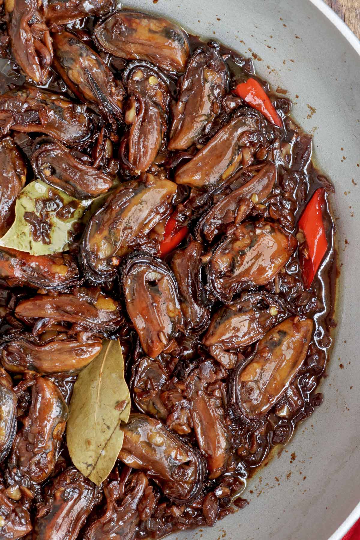 Freshly cooked Adobong Tahong in a pan with red chilies.