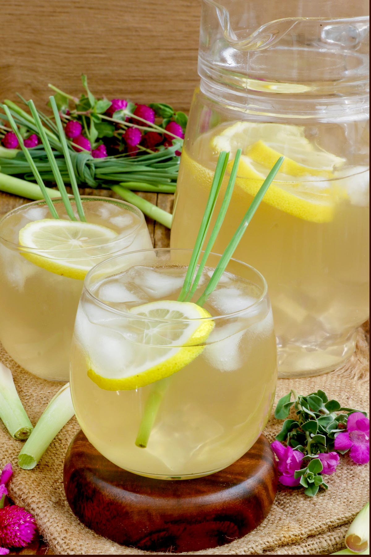 Ice cold drink in glasses with sliced lemon and lemongrass.