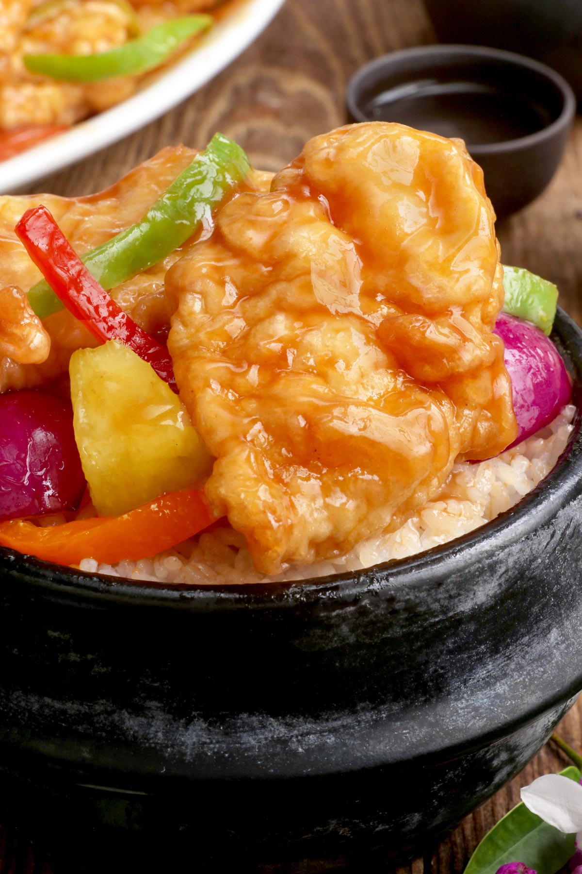 Rice topped with freshly cooked sweet and sour fish fillet with bell pepper strips and pineapple chunks.