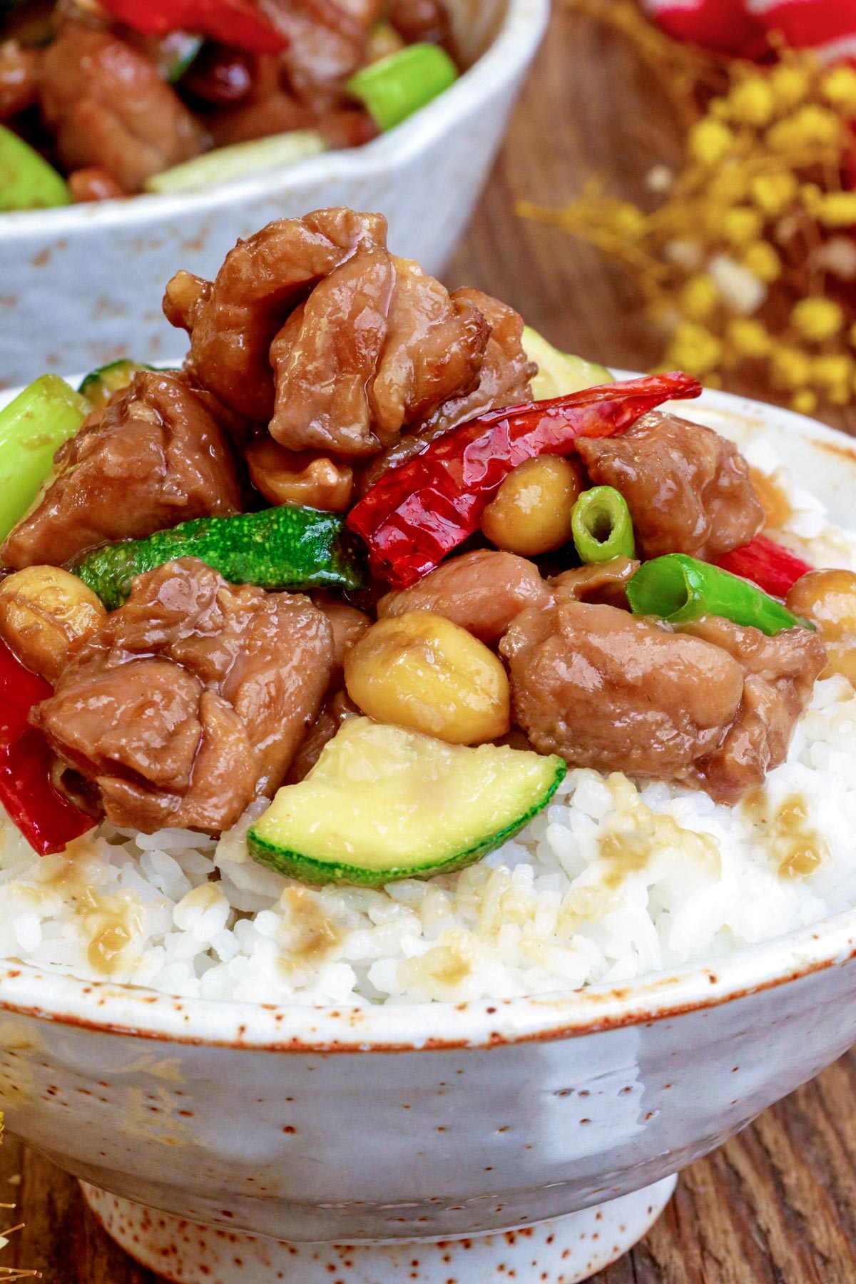 Rice in a bowl topped with delicious Kung Pao Chicken.