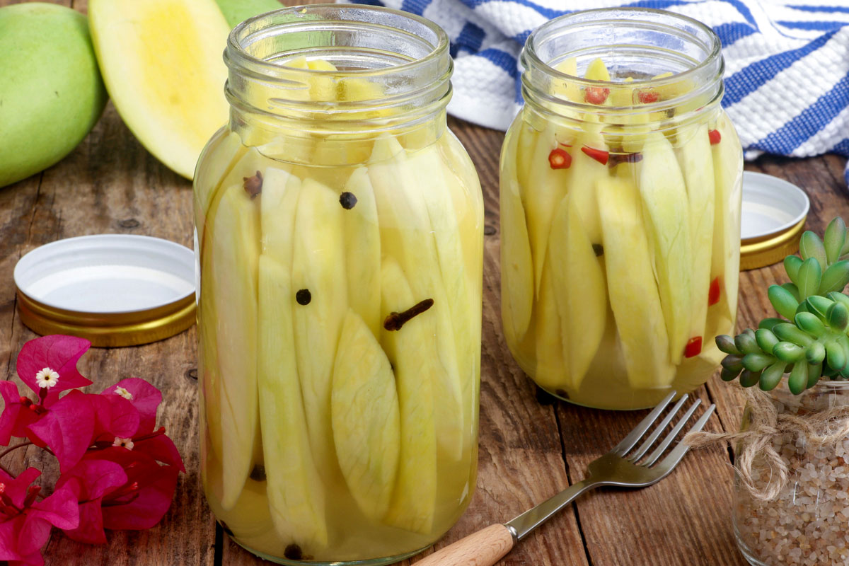 Sweet and tangy pickled mango in storage jars.