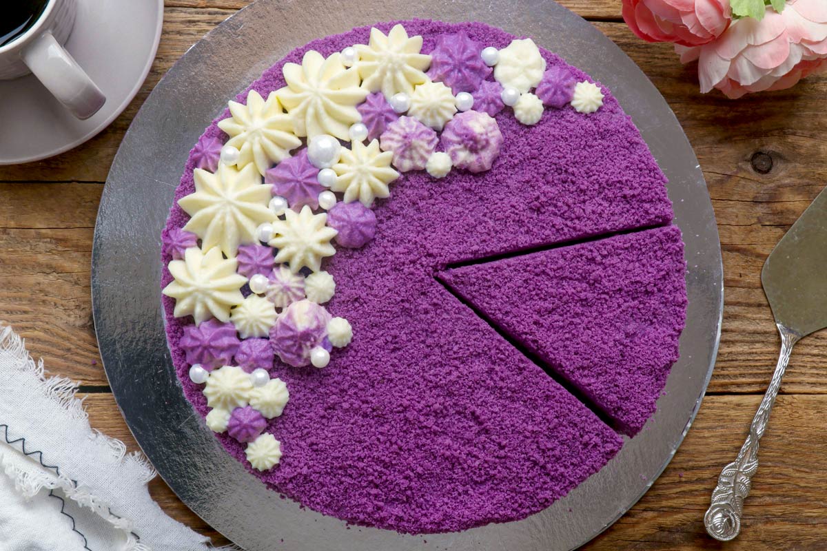 Sliced round ube cake on a serving palte.