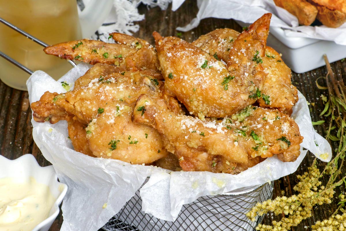 Garlic Parmesan Wings served with dipping sauce and potato wedges.