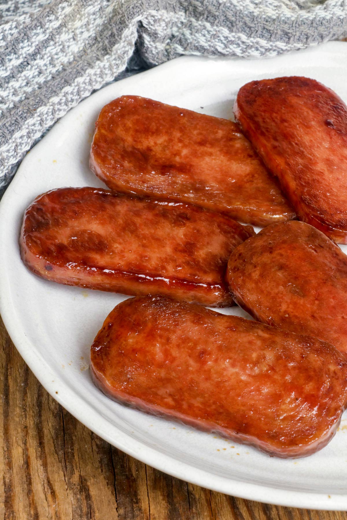 Slices of Spam covered in teriyaki sauce.