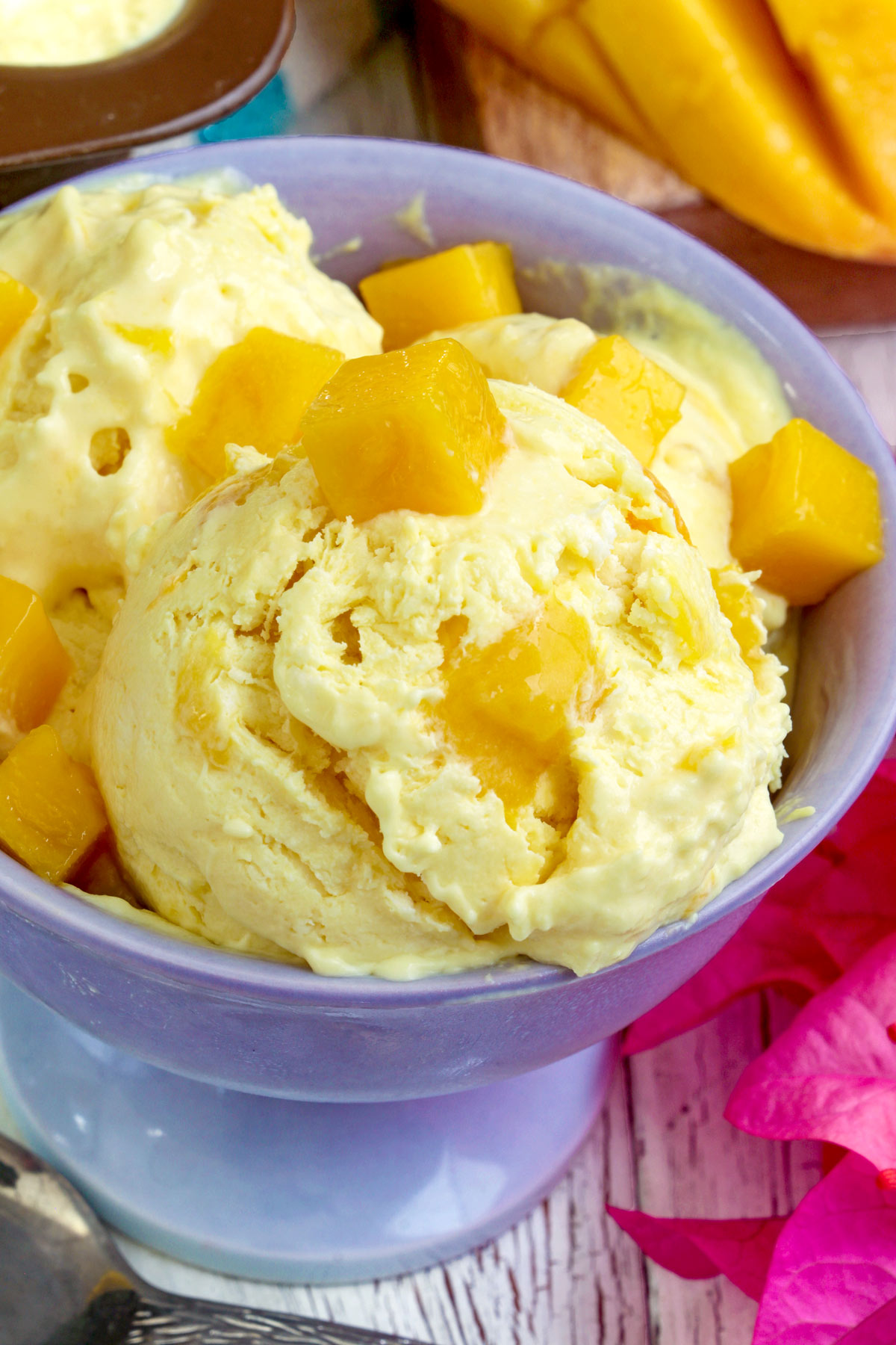 Creamy and smooth Mango Ice Cream served on a bowl with mango bits.
