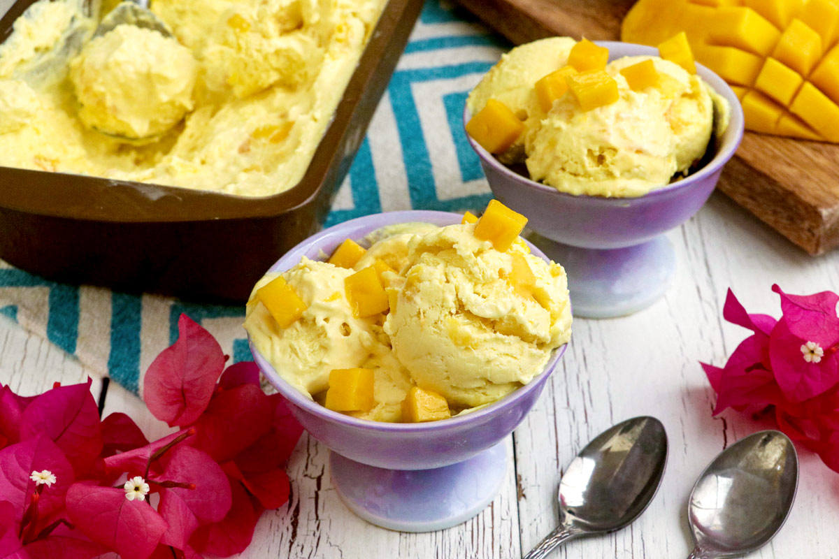 Homemade mango ice cream on dessert bowl with topped with mango cubes.