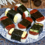 Different varieties of Spam Musubi on a serving plate.