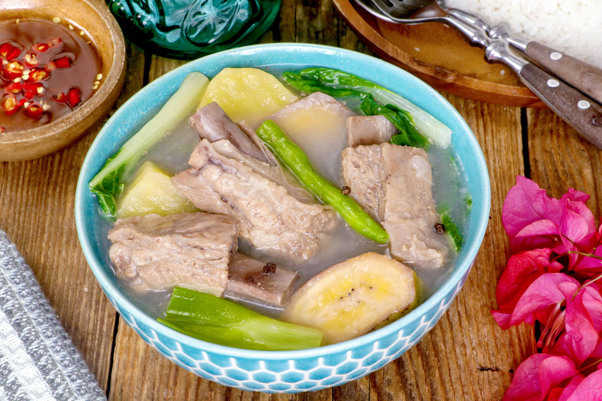 Pork Nilaga in a serving bowl with spiced fish sauce for dipping.