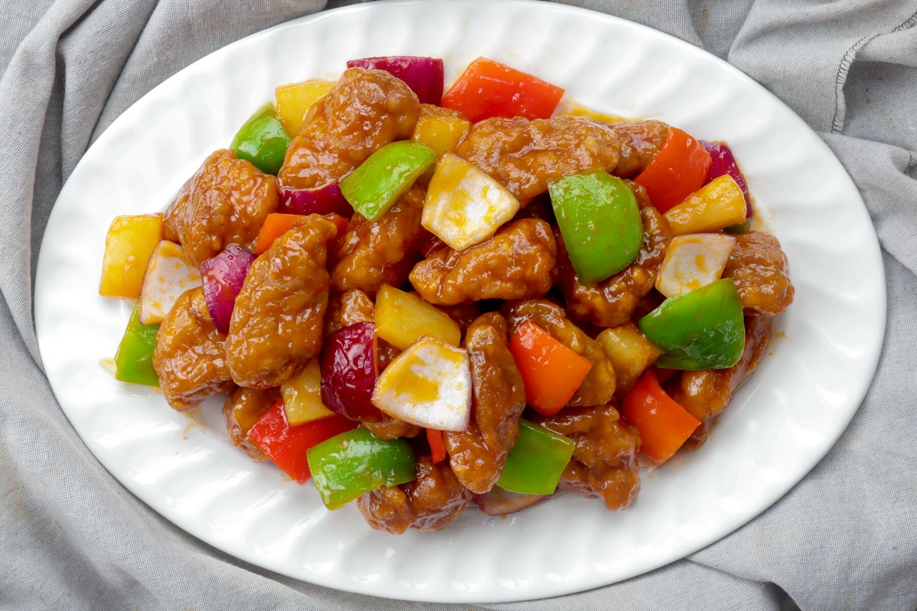 Crispy pork cutlets with bell pepper and pineapple chunks coated in a delicious sweet and sour sauce.