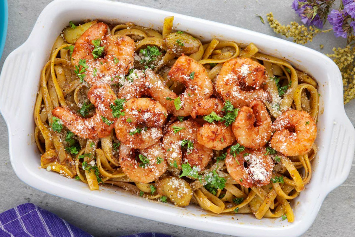 Cajun pasta topped with shrimp, with fresh chopped parsley and grated parmesan cheese.