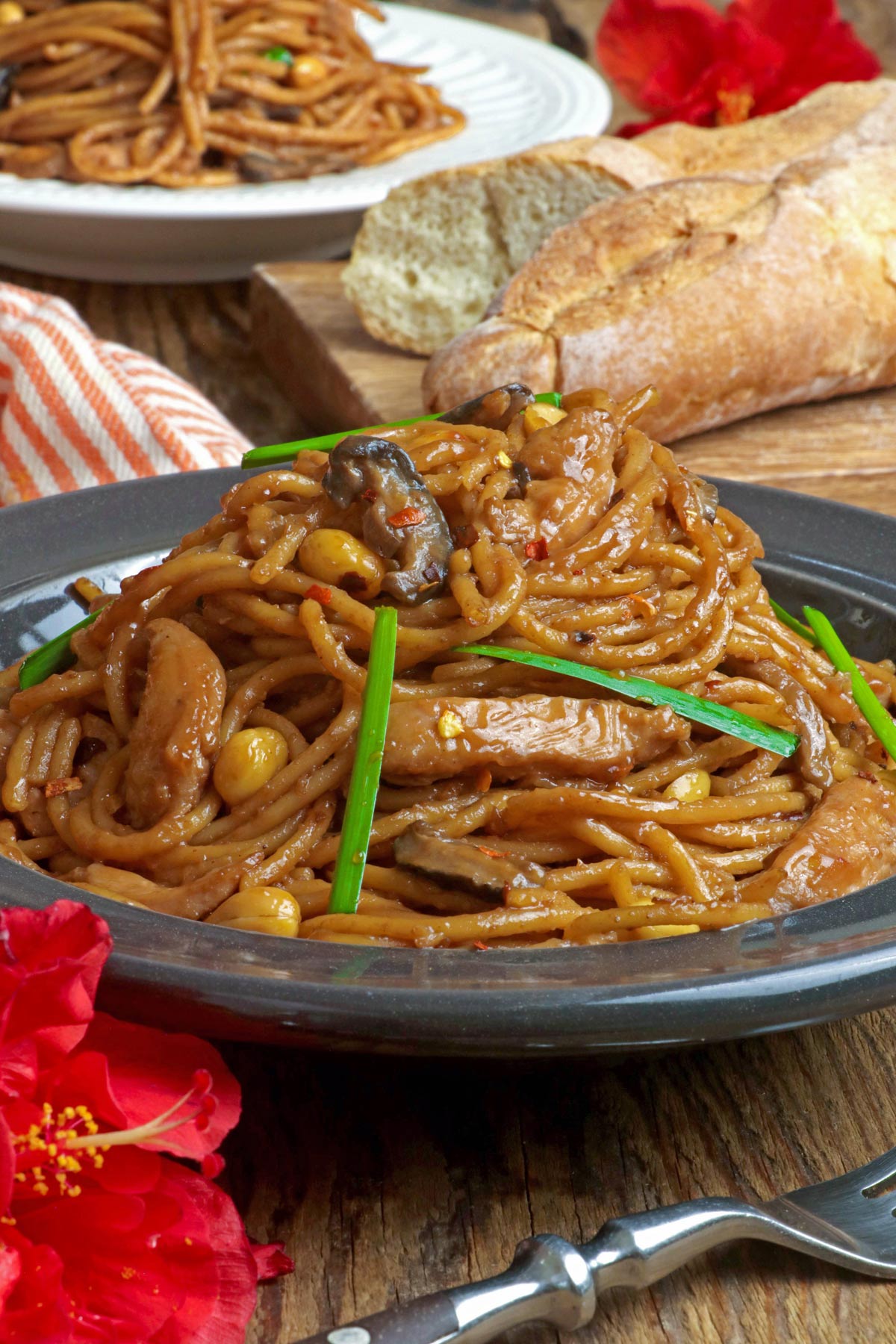 Stir-fried spaghetti in a sticky sweet, savory, and spicy sauce with chicken, mushrooms, and peanuts.
