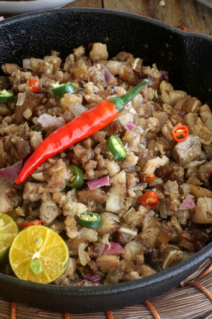 Sizzling sisig in a cast iron pan.