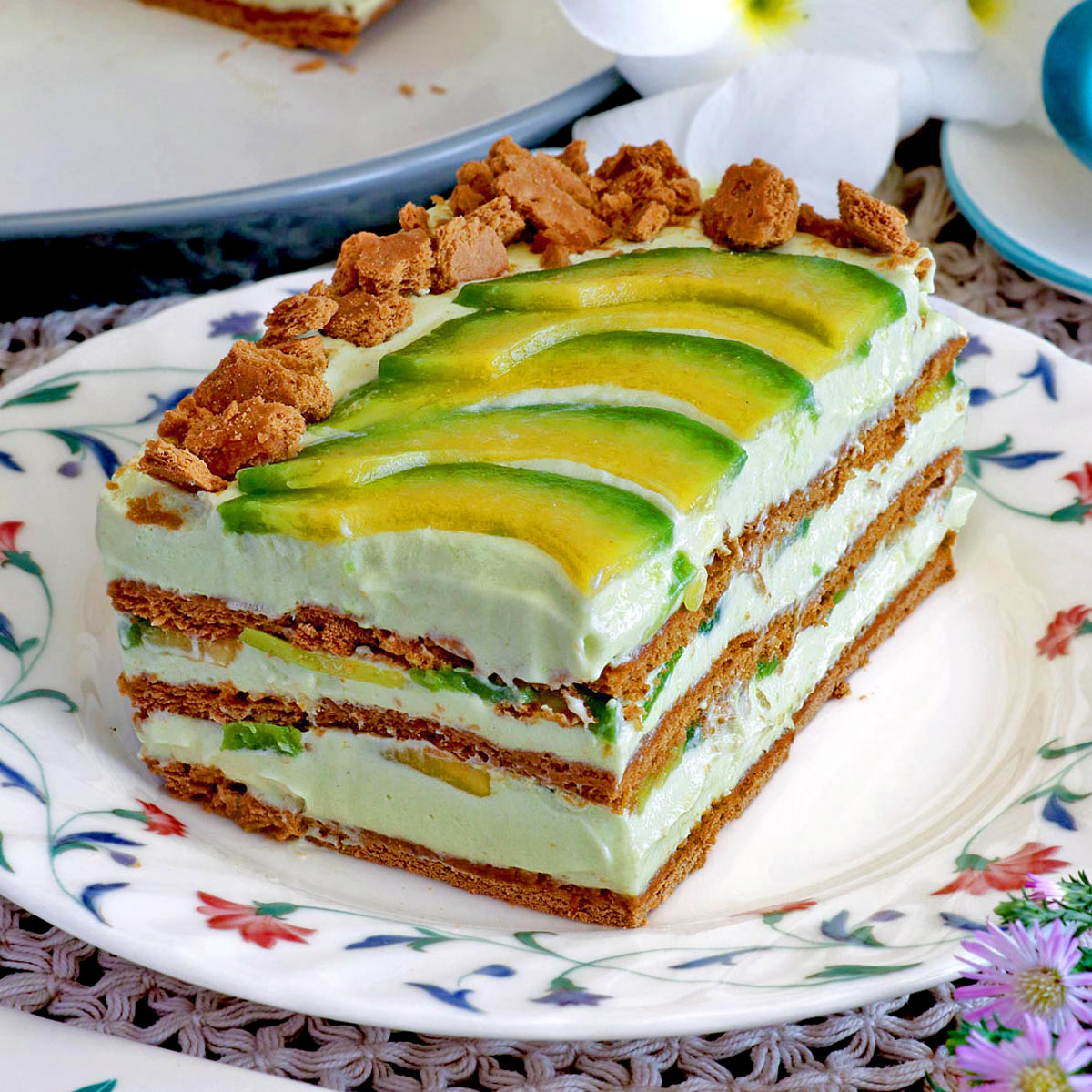 A slice of avocado float topped with slices of avocado and crushed graham crackers.