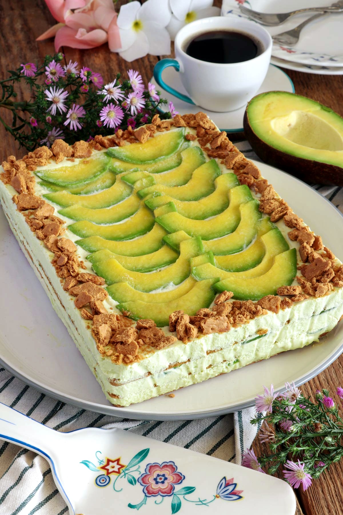 Avocado graham float topped with slices of avocado and crushed graham crackers on a serving plate.