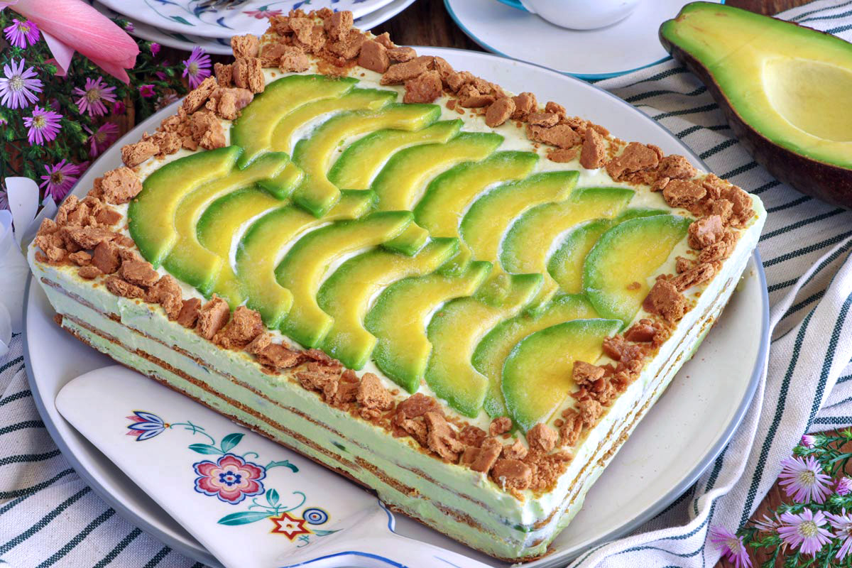 Unsliced avocado graham float topped with slices of avocado and crushed graham crackers on a serving plate.