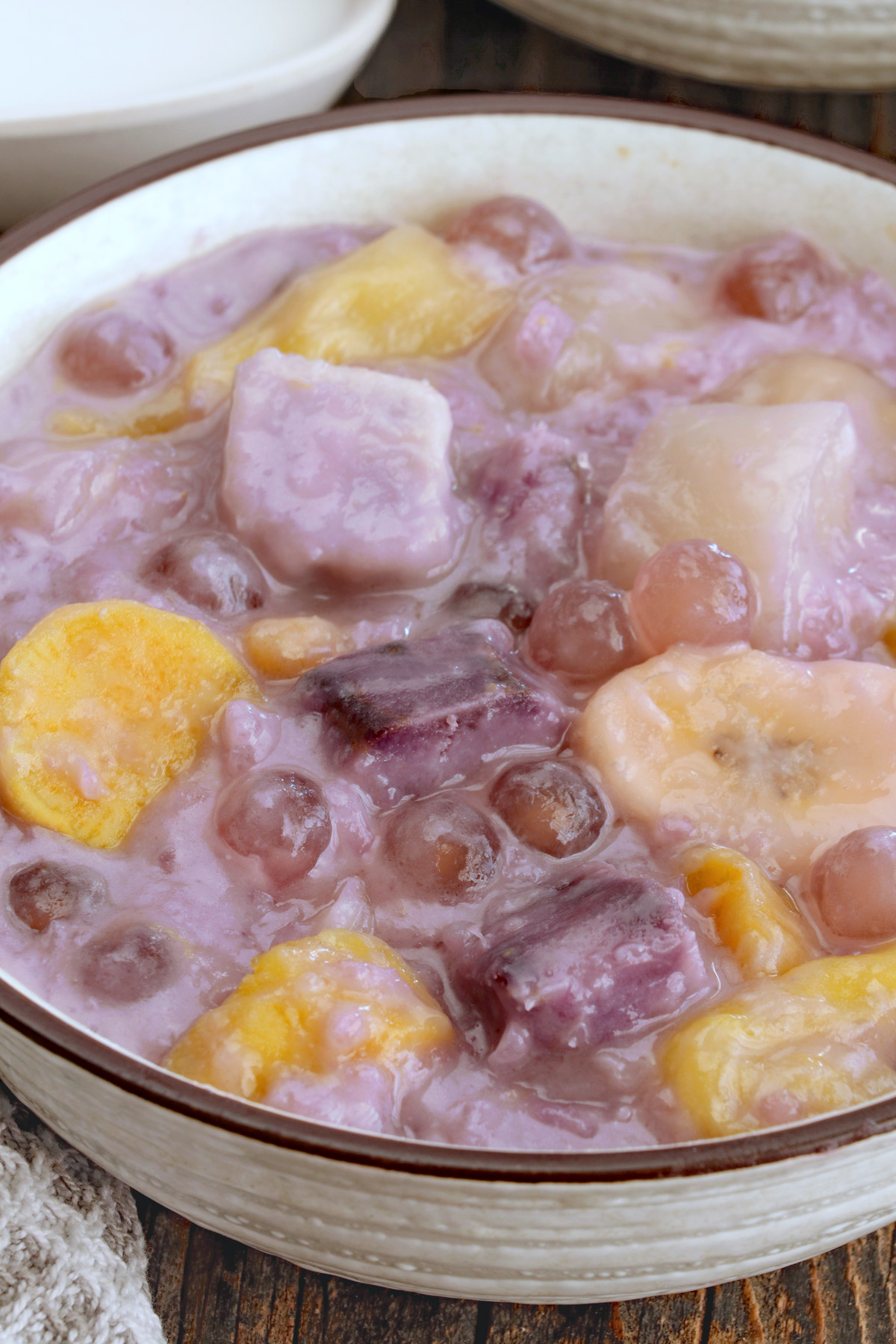 Binignit in a serving bowl with ube, taro, cassava, banana, langka, sago and glutinous rice.