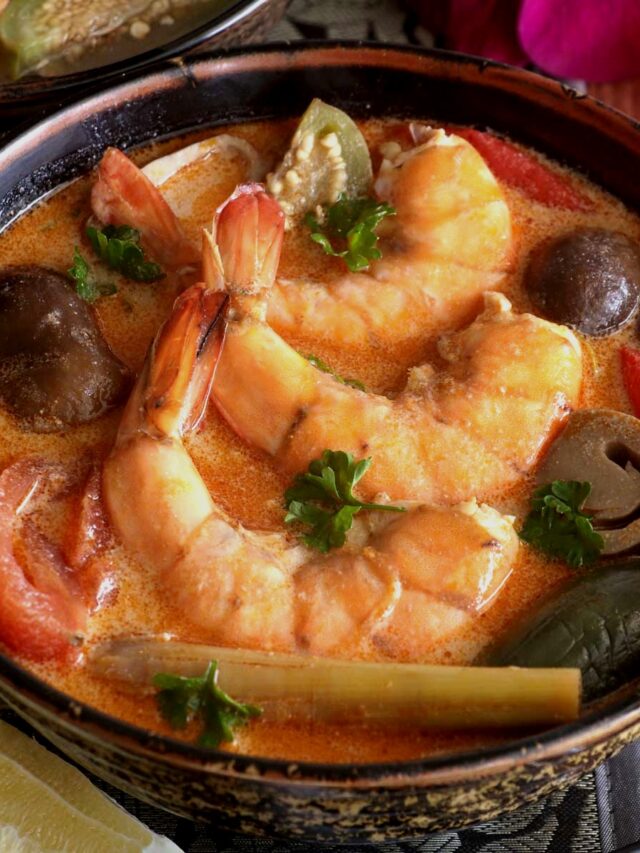 Thai Tom Yum soup in a serving bowl with shrimp garnished with cilantro.