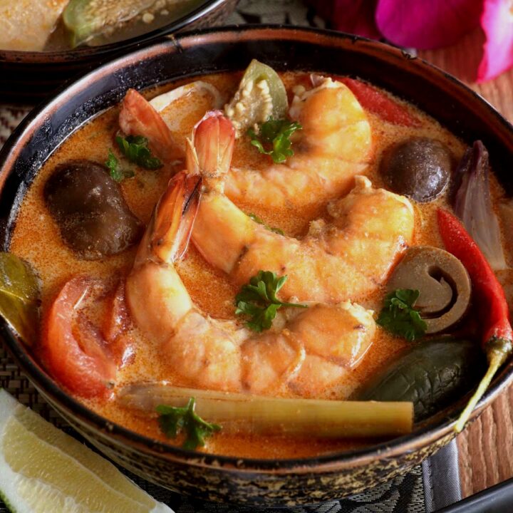Thai Tom Yum soup in a serving bowl with shrimp garnished with cilantro.