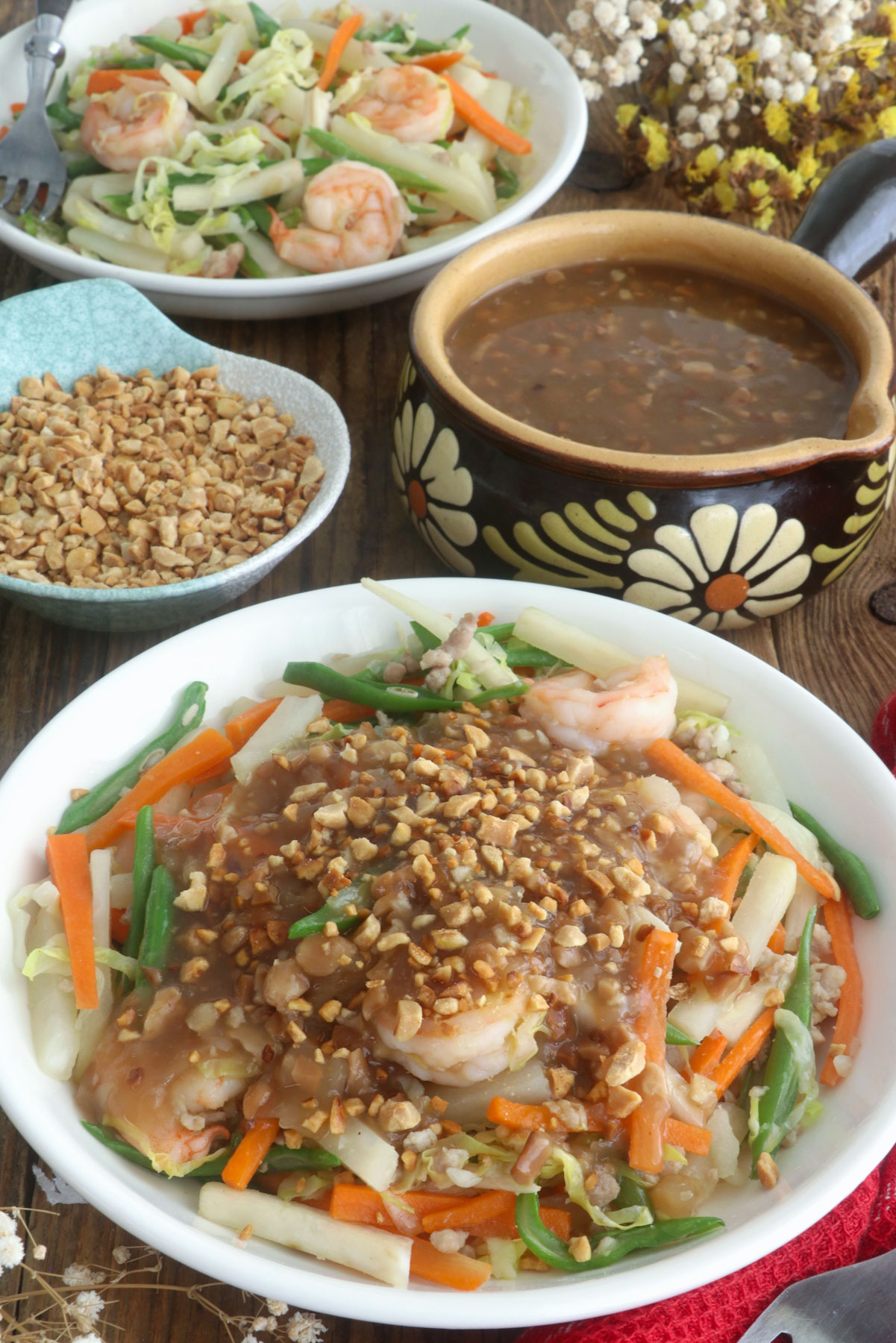 Lumpiang hubad in a serving plate topped with lumpia sauce and ground peanut.